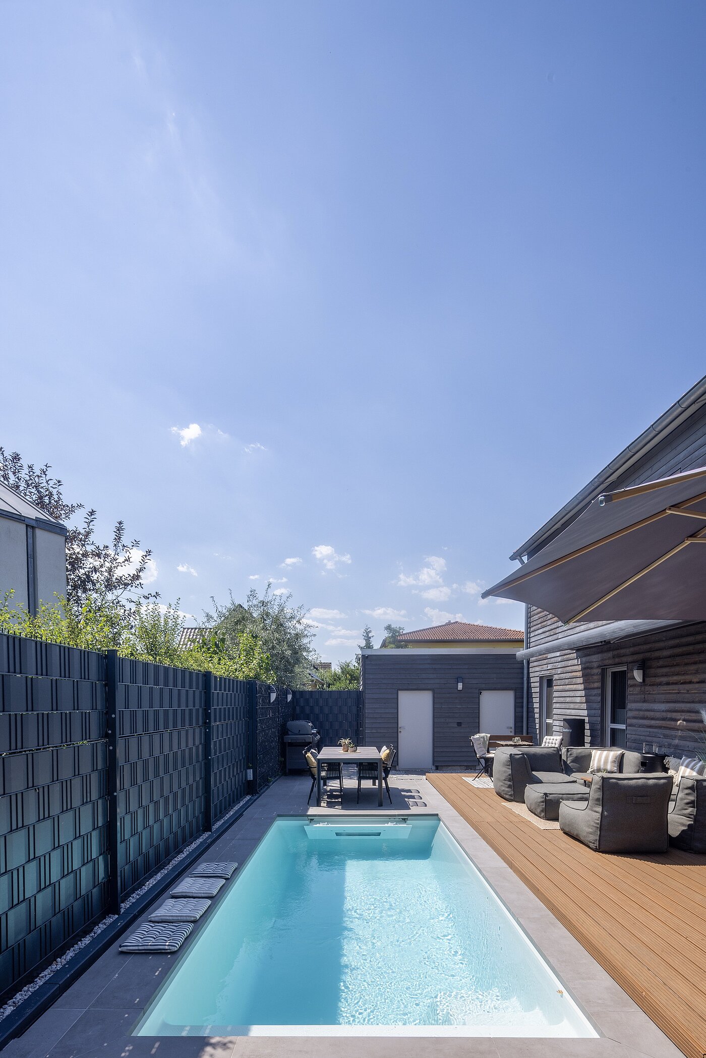Garten mit Pool, Sonnenschirm und Gartenhaus