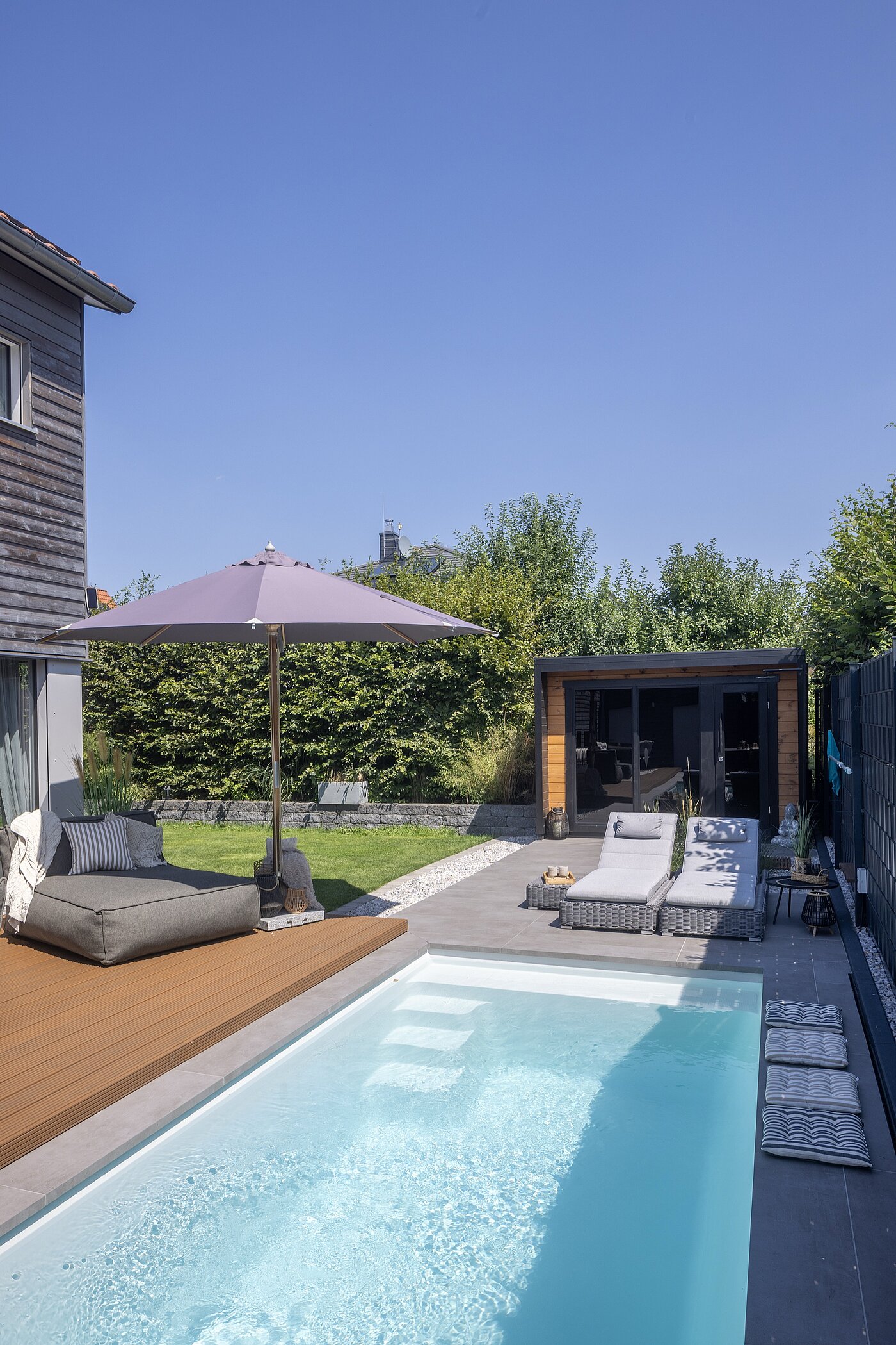 Poolterrasse mit Liegen und Sonnenschirm